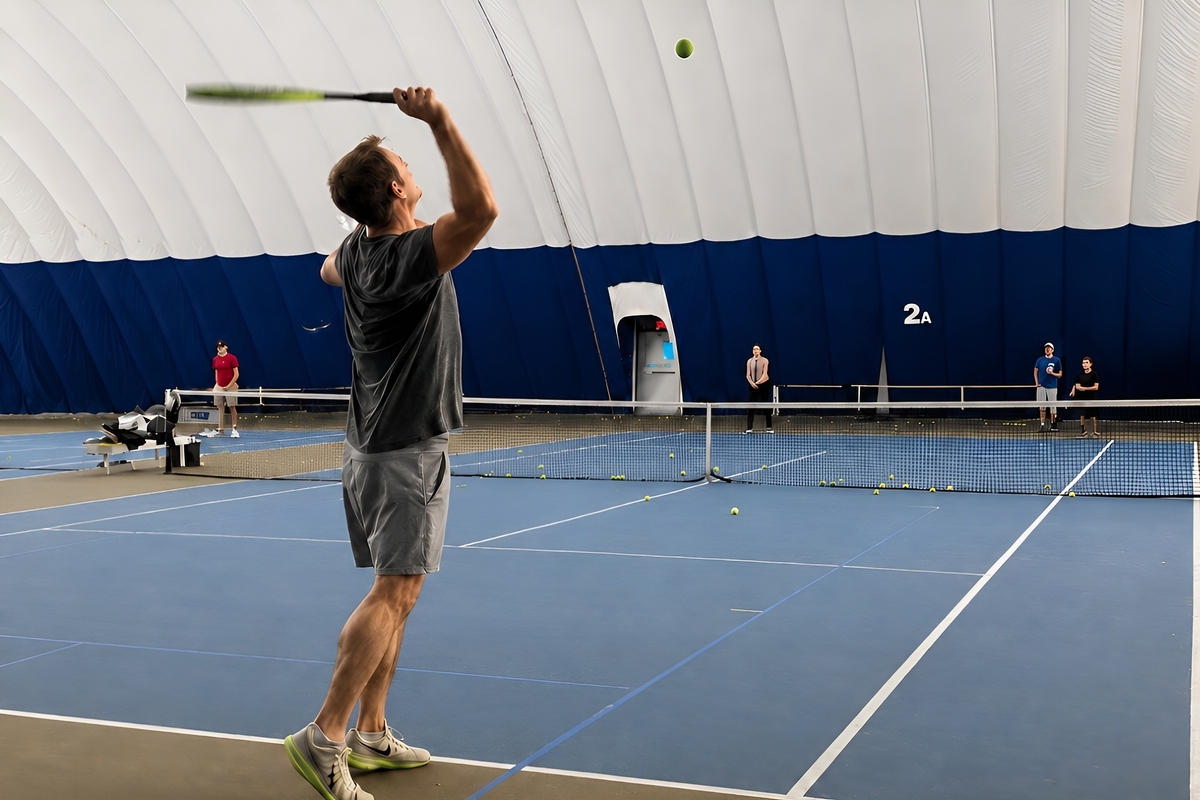 Player serving under the bubble at Junction Indoor Tennis Center